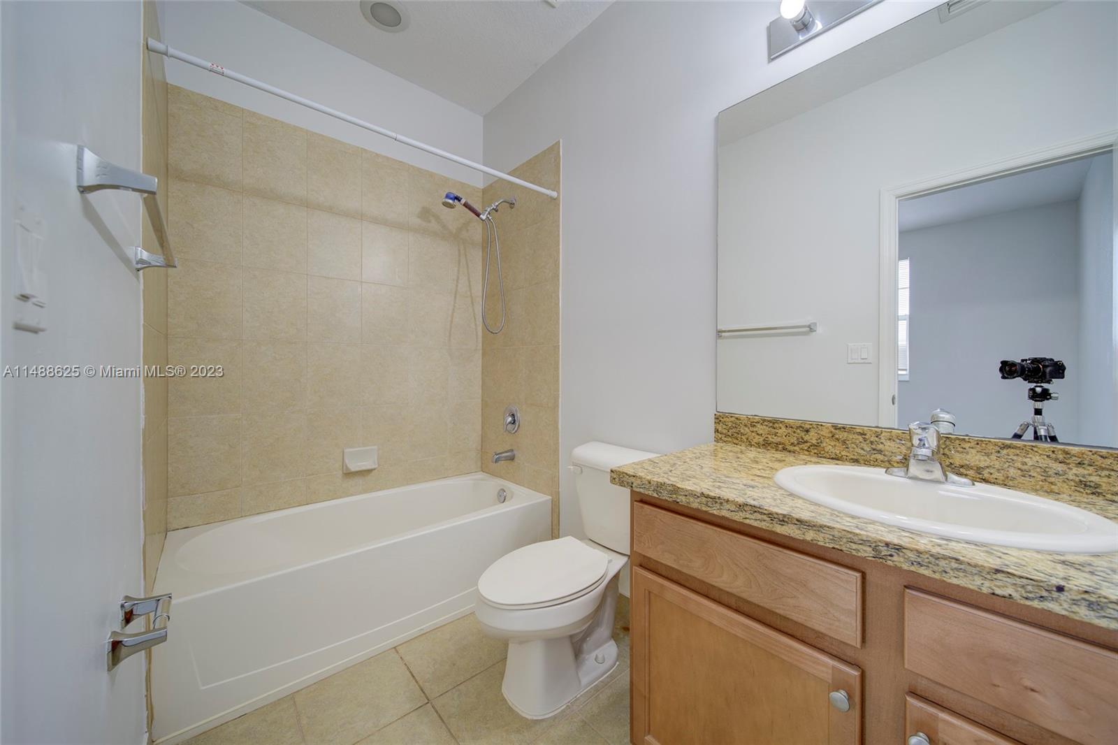 14679 Southwest 9th Street, Unit 1801 Pembroke Pines, FL 33027 - Photo 25 of 26 a bathroom with a granite countertop toilet a sink and a bathtub