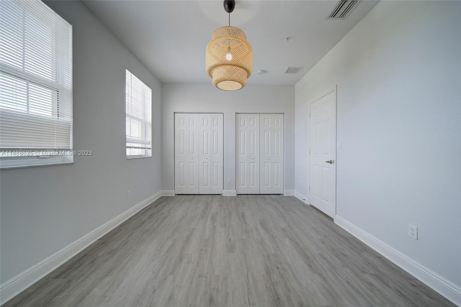 14679 Southwest 9th Street, Unit 1801 Pembroke Pines, FL 33027 - Photo 26 of 26 an empty room with wooden floor and windows