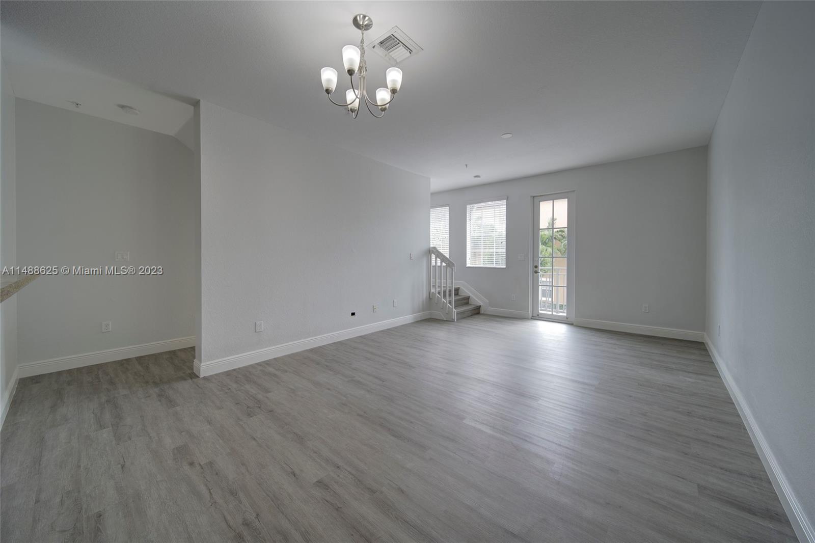 14679 Southwest 9th Street, Unit 1801 Pembroke Pines, FL 33027 - Photo 4 of 26 a view of empty room with wooden floor and window