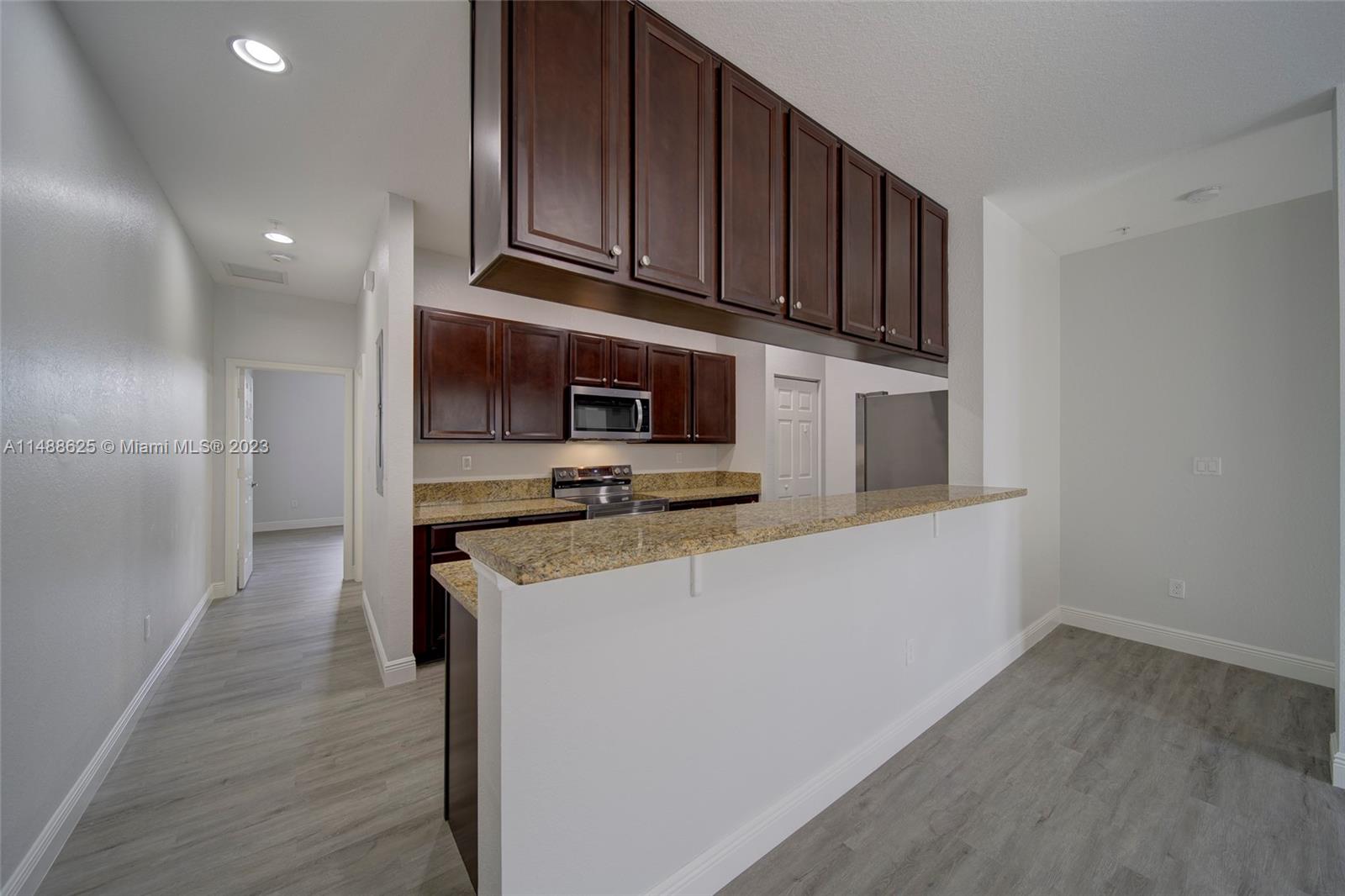 14679 Southwest 9th Street, Unit 1801 Pembroke Pines, FL 33027 - Photo 10 of 26 a kitchen with stainless steel appliances granite countertop a refrigerator a stove and a wooden floors