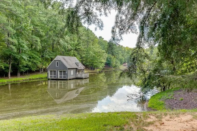 a view of a lake with a yard and large trees