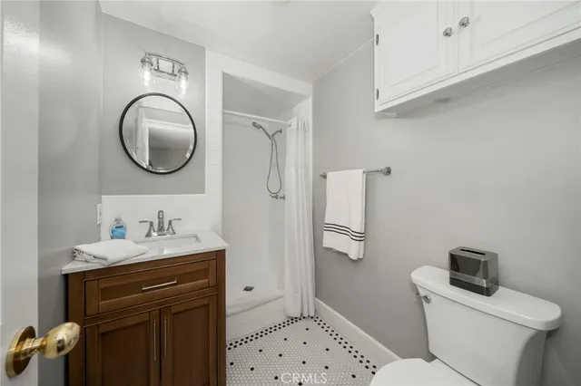 a bathroom with a sink a toilet and a mirror