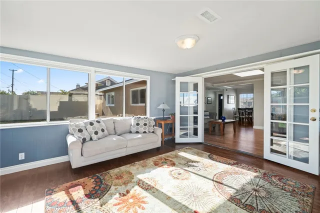 a living room with furniture large window and wooden floor