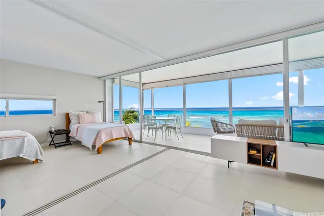 a bedroom with a bed and a flat tv screen on dresser