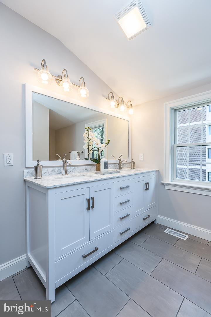 111 West Montgomery Avenue, Unit 107 Ardmore, PA 19003 - Photo 31 of 44 a bathroom with a double vanity sink mirror and a bathtub