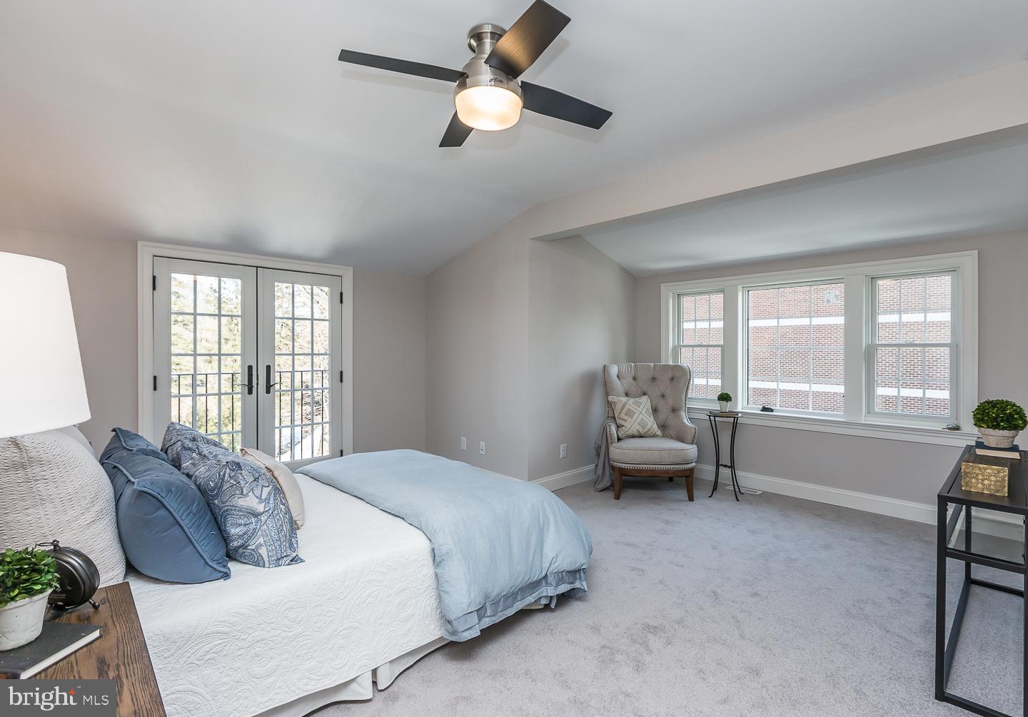 111 West Montgomery Avenue, Unit 107 Ardmore, PA 19003 - Photo 34 of 44 a spacious bedroom with a bed and a chandelier