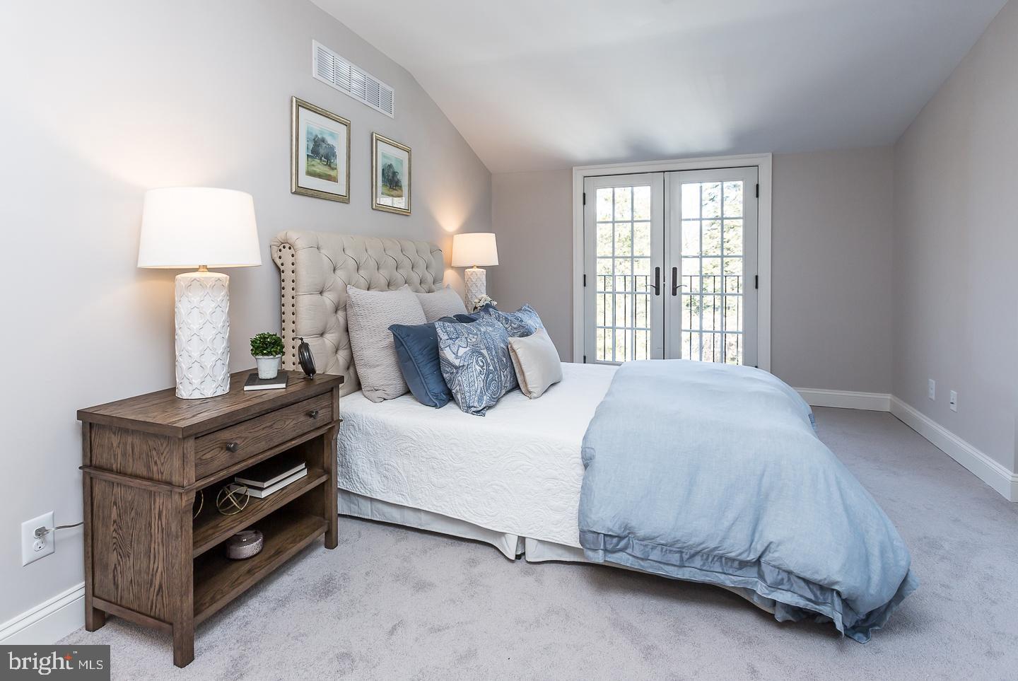111 West Montgomery Avenue, Unit 107 Ardmore, PA 19003 - Photo 35 of 44 a bedroom with a bed and a lamp on the dresser