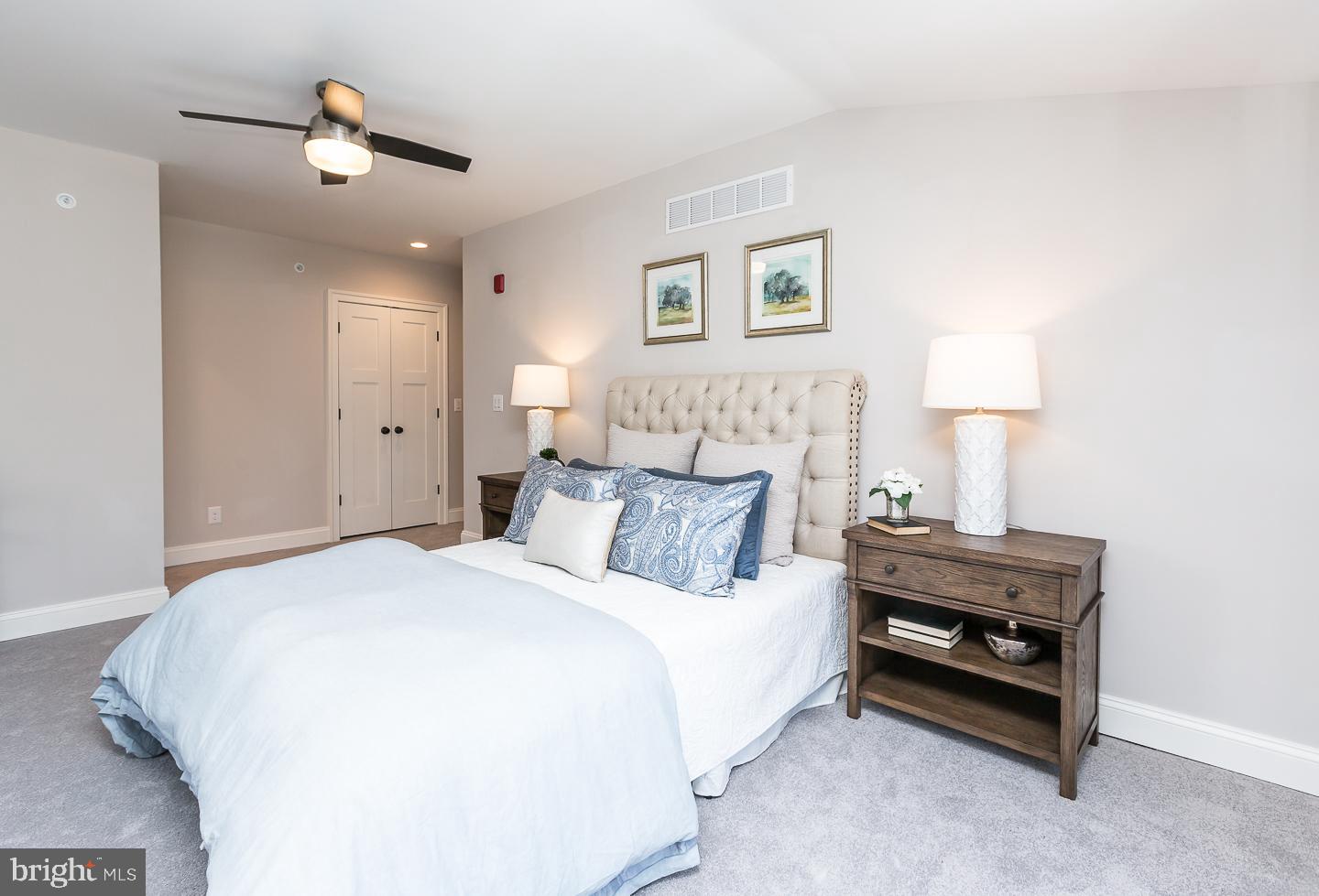 111 West Montgomery Avenue, Unit 107 Ardmore, PA 19003 - Photo 37 of 44 a bedroom with a bed and a lamp on table