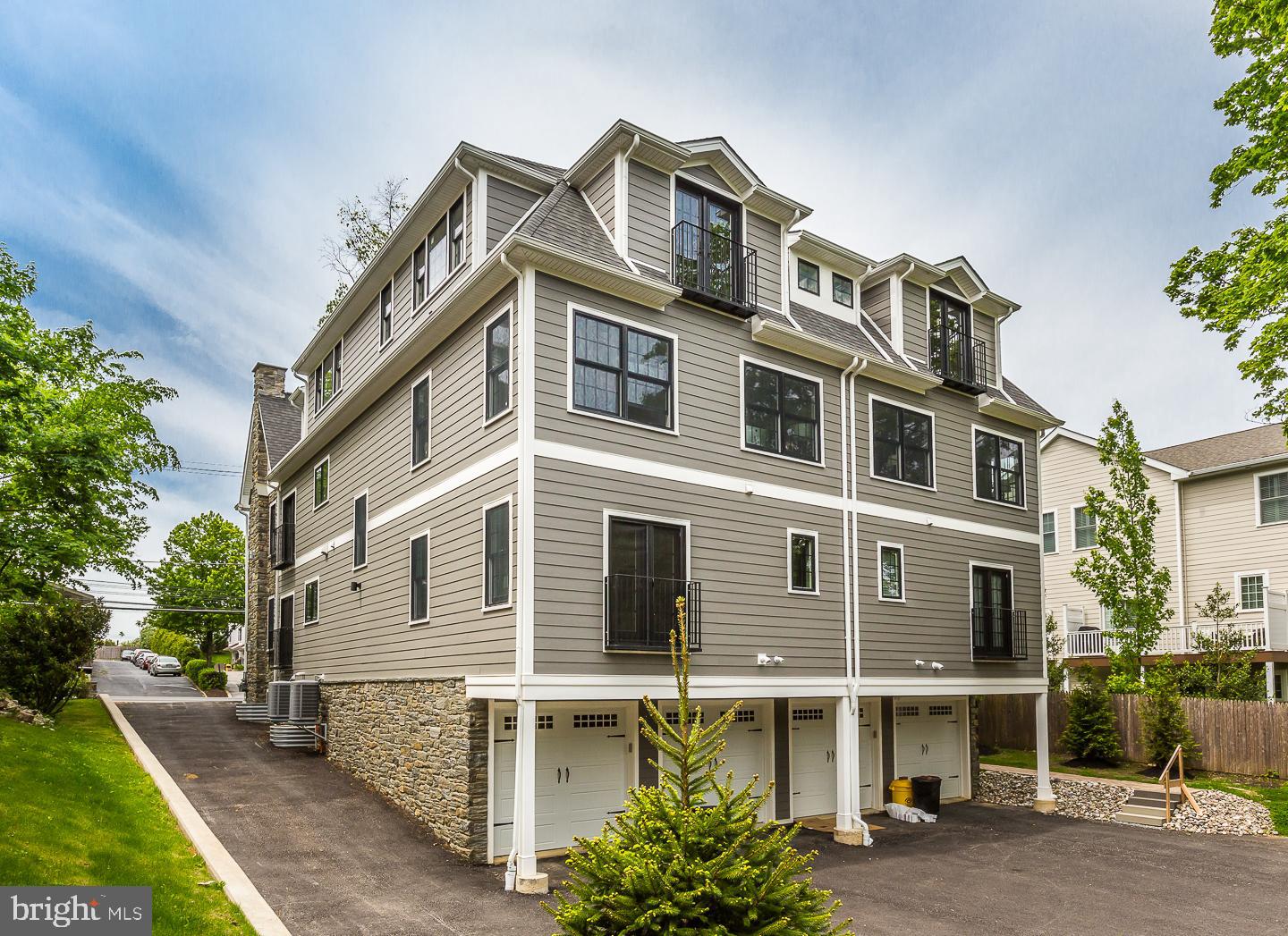 111 West Montgomery Avenue, Unit 107 Ardmore, PA 19003 - Photo 44 of 44 a front view of a building with a garden and plants