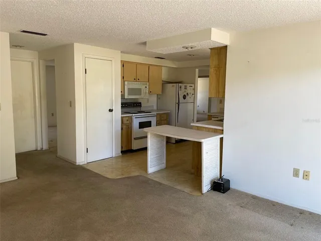 a view of a kitchen with refrigerator and stove