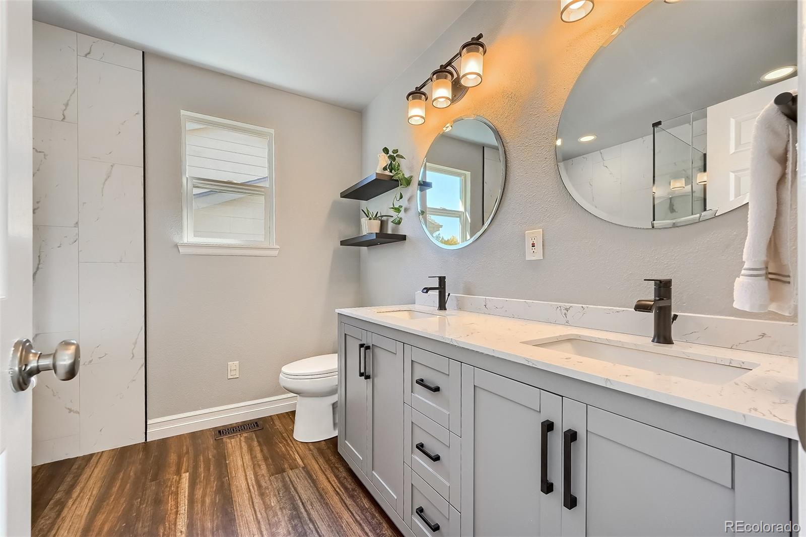 1076 Timbervale Trail Highlands Ranch, CO 80129 - Photo 18 of 29 a spacious bathroom with a granite countertop sink mirror and toilet