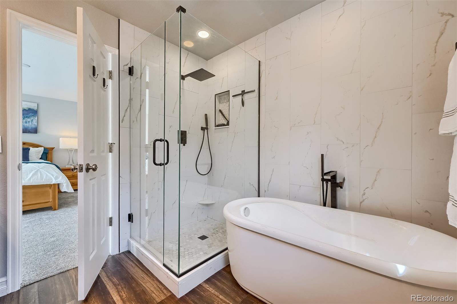 1076 Timbervale Trail Highlands Ranch, CO 80129 - Photo 19 of 29 a bathroom with a shower a bathtub and a shower
