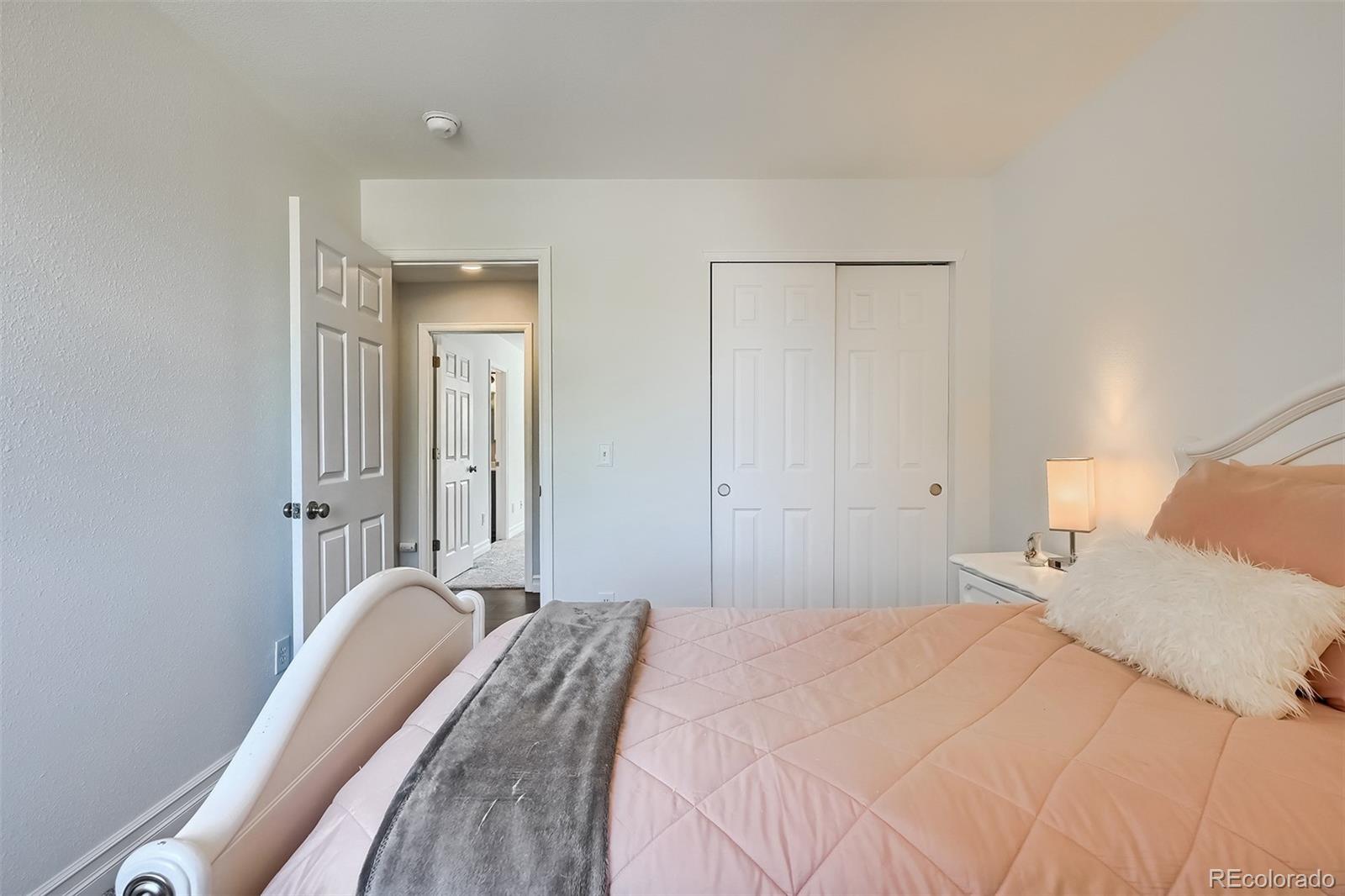 1076 Timbervale Trail Highlands Ranch, CO 80129 - Photo 21 of 29 a bedroom with a bed and a chandelier