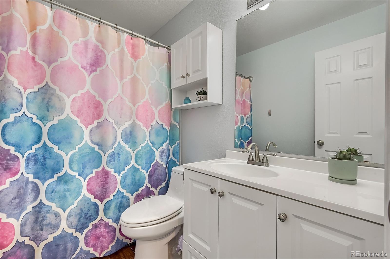 1076 Timbervale Trail Highlands Ranch, CO 80129 - Photo 24 of 29 a bathroom with a sink mirror and toilet