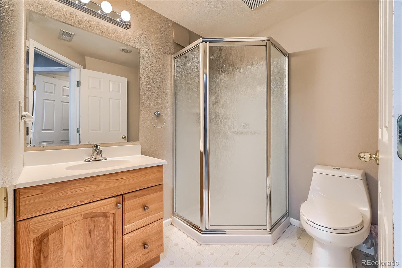 1076 Timbervale Trail Highlands Ranch, CO 80129 - Photo 27 of 29 a bathroom with a sink a toilet and a mirror