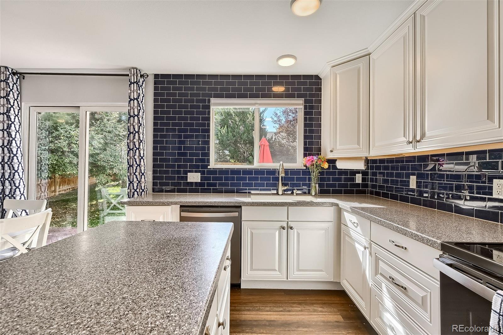1076 Timbervale Trail Highlands Ranch, CO 80129 - Photo 6 of 29 a kitchen with a sink stove and cabinets