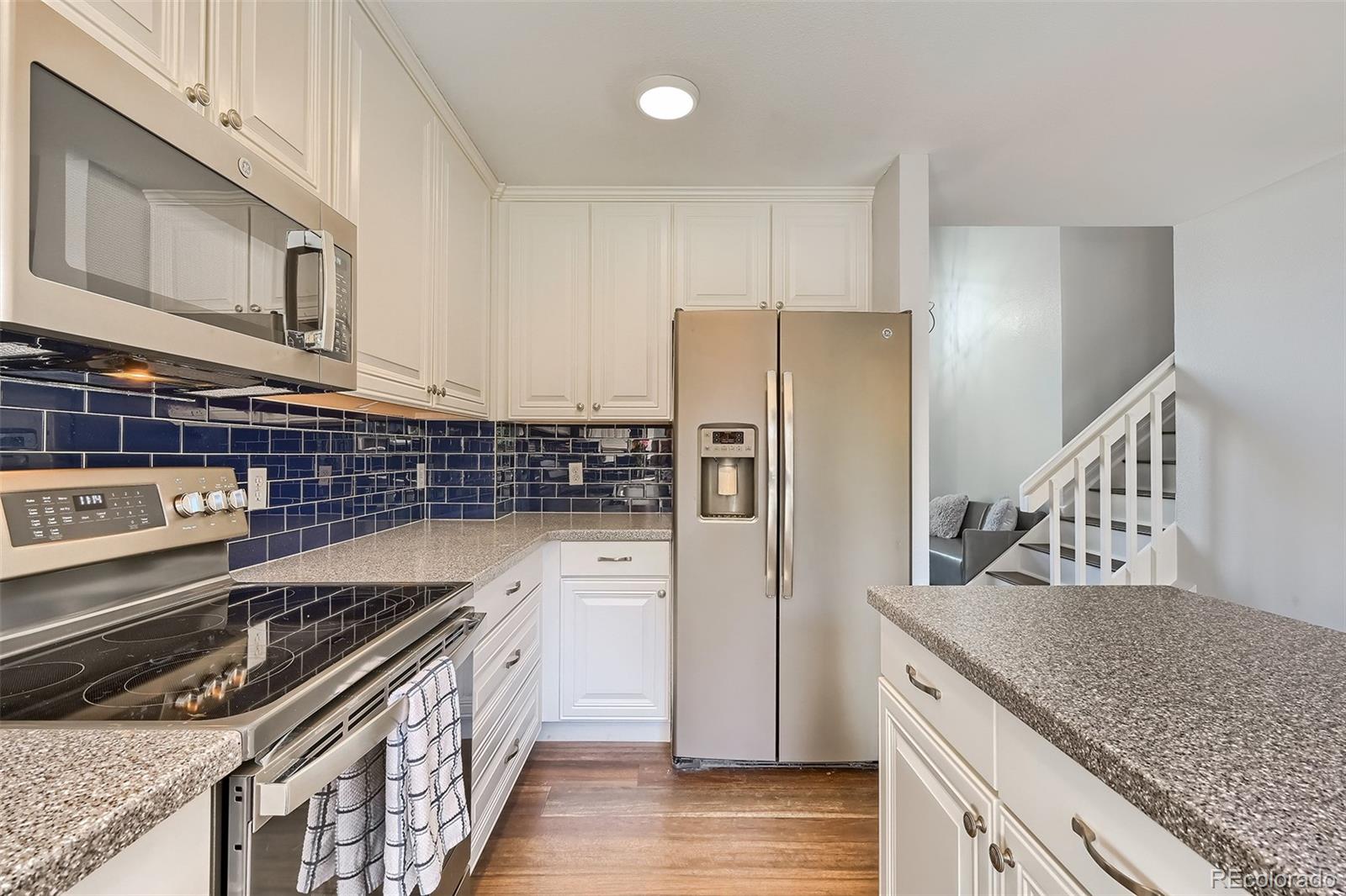 1076 Timbervale Trail Highlands Ranch, CO 80129 - Photo 8 of 29 a kitchen with stainless steel appliances granite countertop a stove a refrigerator and a sink