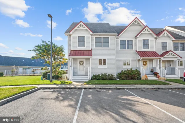 a view of a white house with a yard and plants