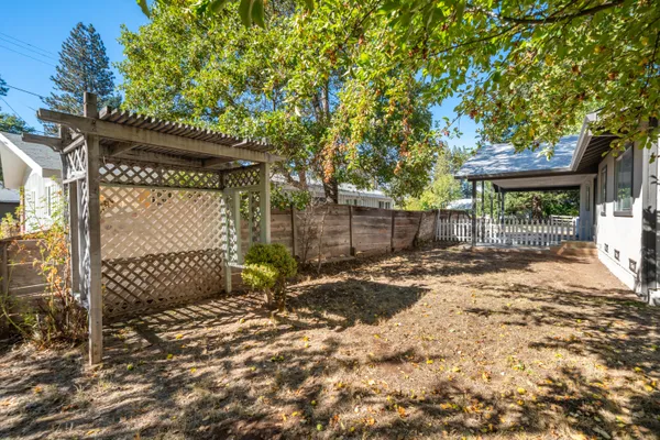 a backyard of a house with a swing chair and wooden fence