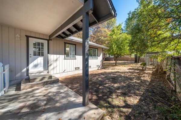 a view of a house with backyard and a tree