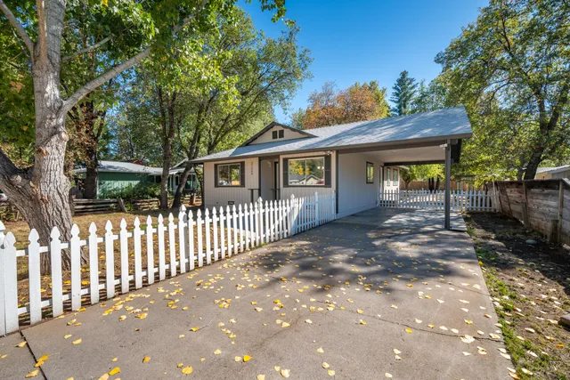 a view of a house with a small yard and wooden fence