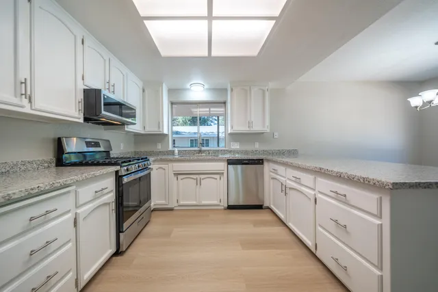 a kitchen with stainless steel appliances granite countertop a sink and cabinets