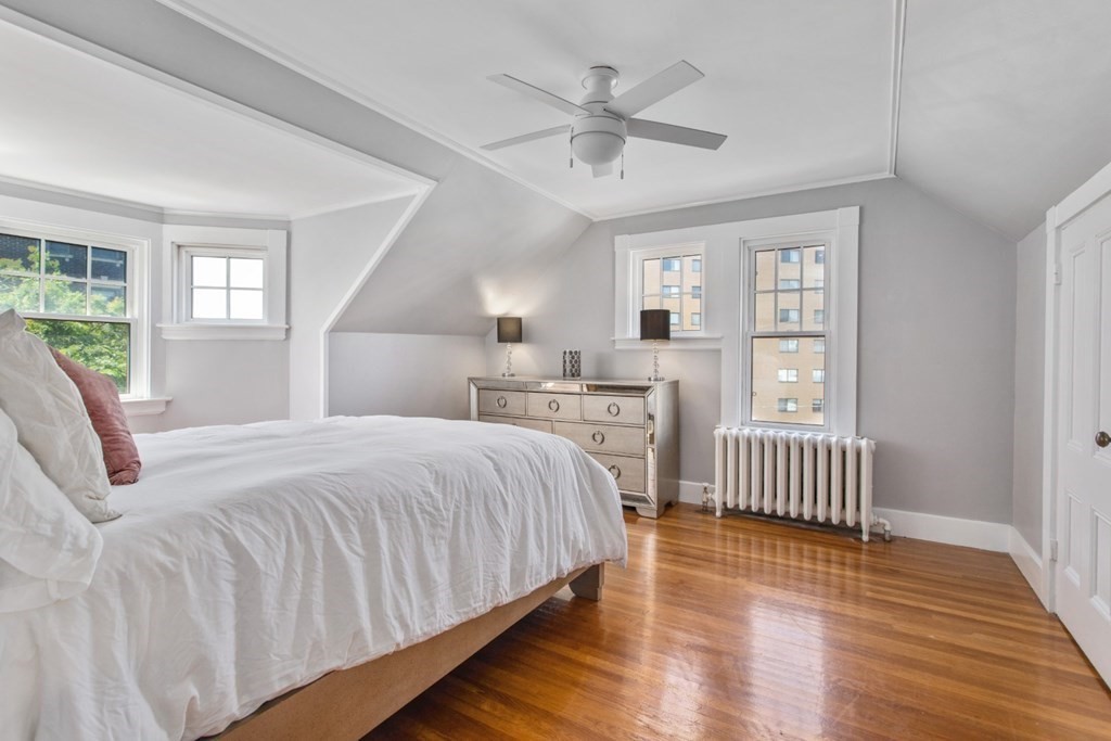 28 Wave Street, Unit 2 Lynn, MA 01902 - Photo 24 of 36 a bedroom with a bed and a large window with wooden floor