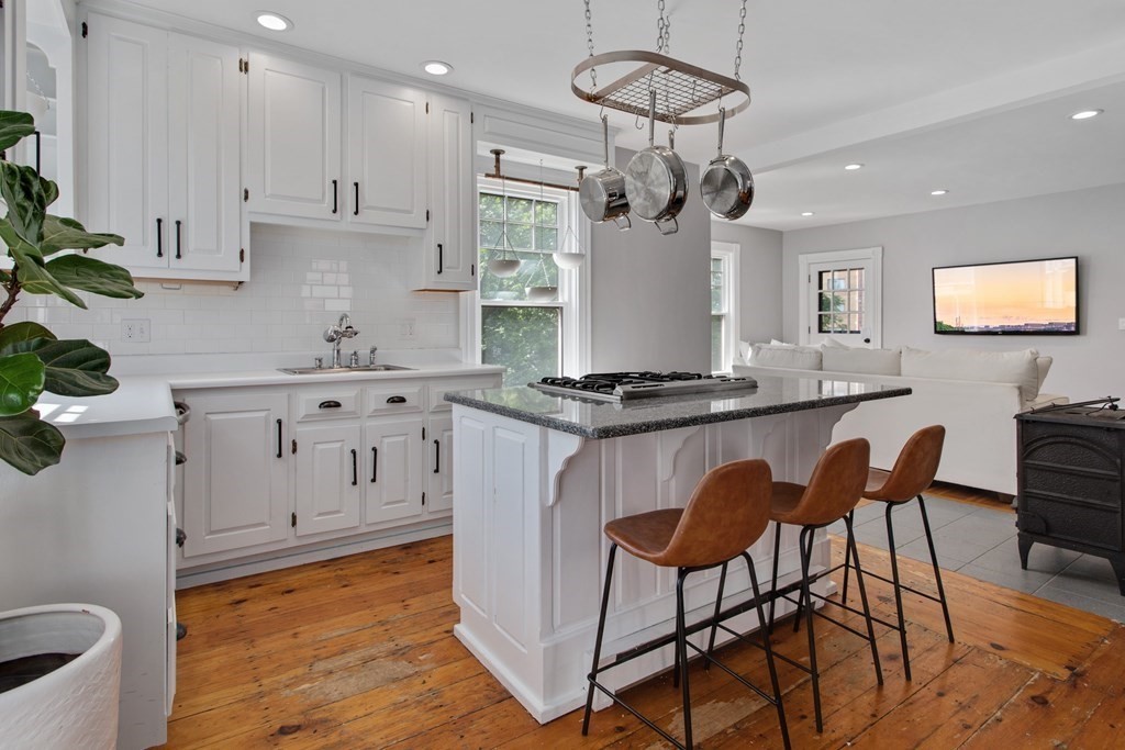 28 Wave Street, Unit 2 Lynn, MA 01902 - Photo 10 of 36 a kitchen with stainless steel appliances granite countertop a stove a sink a dining table and chairs with wooden floor