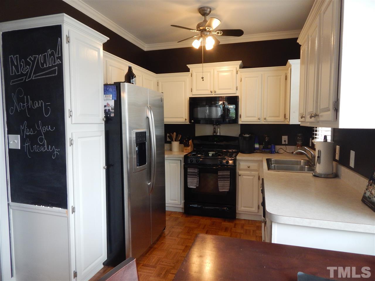 910 Albany Court Raleigh, NC 27615 - Photo 7 of 14 a kitchen with stainless steel appliances a refrigerator a stove a microwave and cabinets