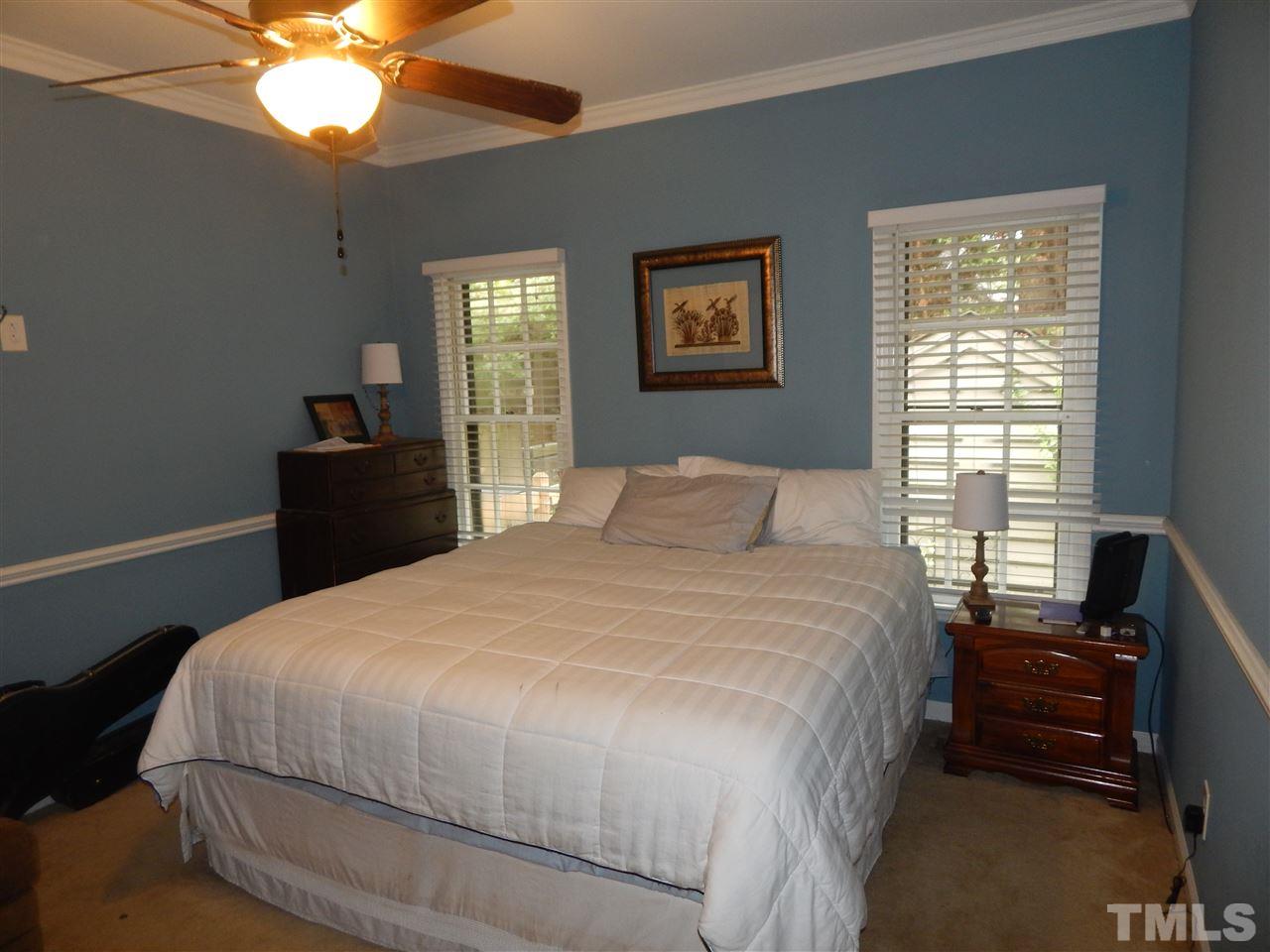 910 Albany Court Raleigh, NC 27615 - Photo 9 of 14 a bedroom with a bed and a chandelier