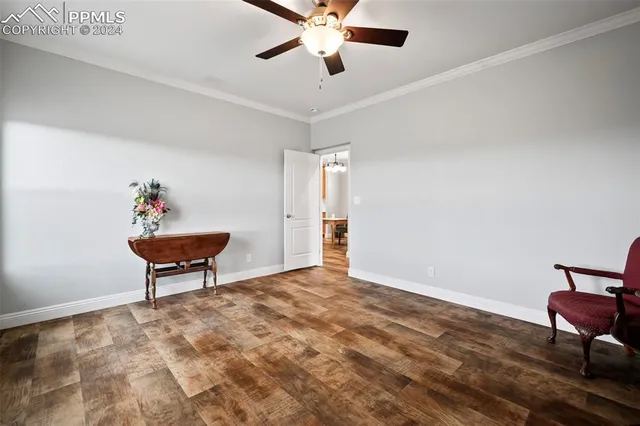 a workspace room with wooden floor and a ceiling fan
