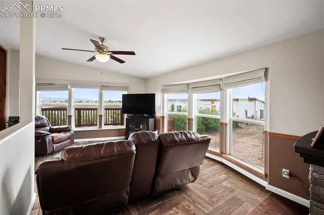 a living room with furniture a flat screen tv and a large window