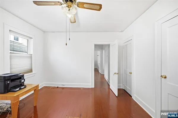 a view of a room with wooden floor and ceiling fan