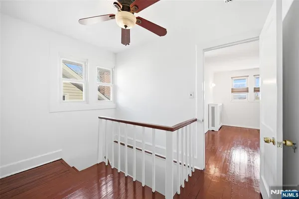 a view of a hallway with wooden floor and staircase
