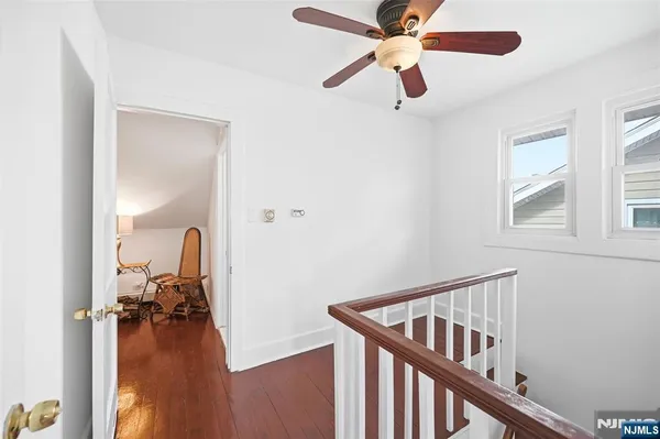 a view of a hallway with workspace and a livingroom with wooden floor