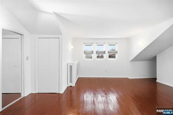 a view of a big room with wooden floor and windows