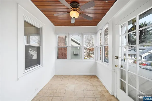 a view of empty room with window and ceiling fan