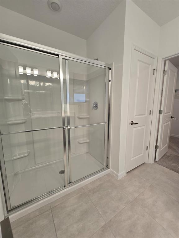 1373 Addison Blf Lane Kissimmee, FL 34744 - Photo 11 of 15 a bathroom with a glass shower door
