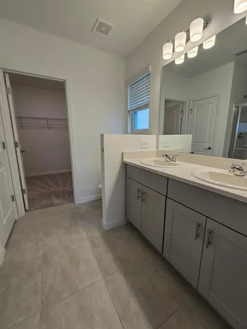 a bathroom with a double vanity sink and a mirror