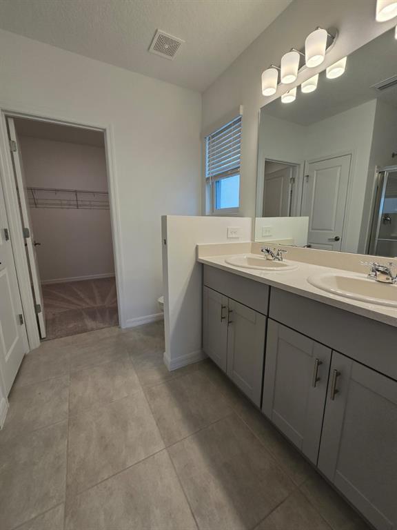 1373 Addison Blf Lane Kissimmee, FL 34744 - Photo 12 of 15 a bathroom with a double vanity sink and a mirror