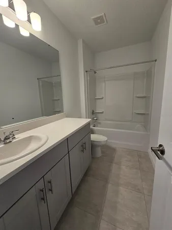 a spacious bathroom with a bathtub sink and mirror