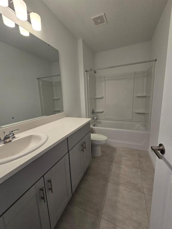 1373 Addison Blf Lane Kissimmee, FL 34744 - Photo 14 of 15 a spacious bathroom with a bathtub sink and mirror