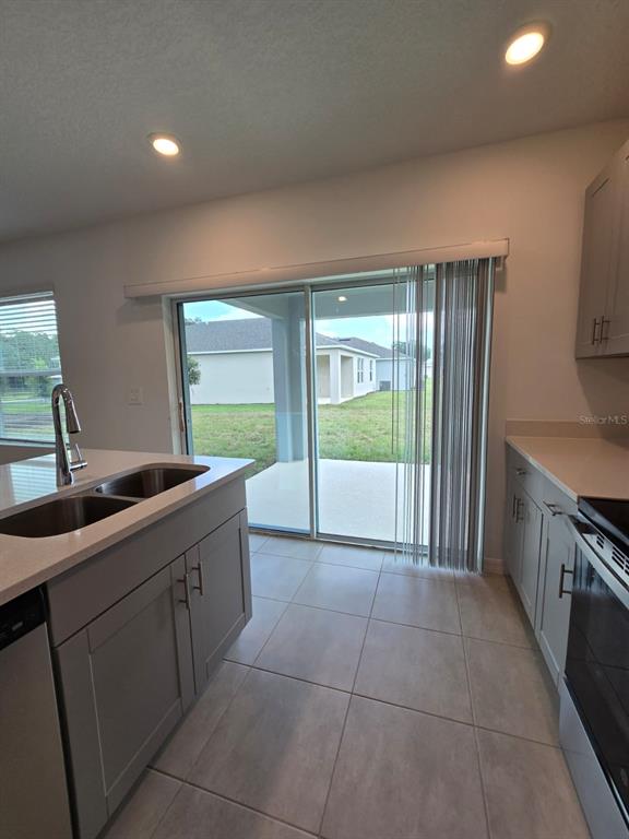 1373 Addison Blf Lane Kissimmee, FL 34744 - Photo 5 of 15 a large kitchen with a sink and dishwasher a stove top oven with large window