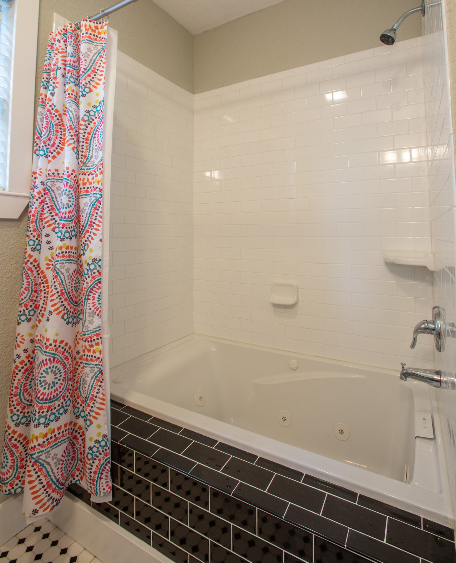 702 West N Loop Boulevard Austin, TX 78751 - Photo 7 of 23 Relax in this well-appointed bathroom featuring a jetted tub, subway tile surround, and classic flooring.
