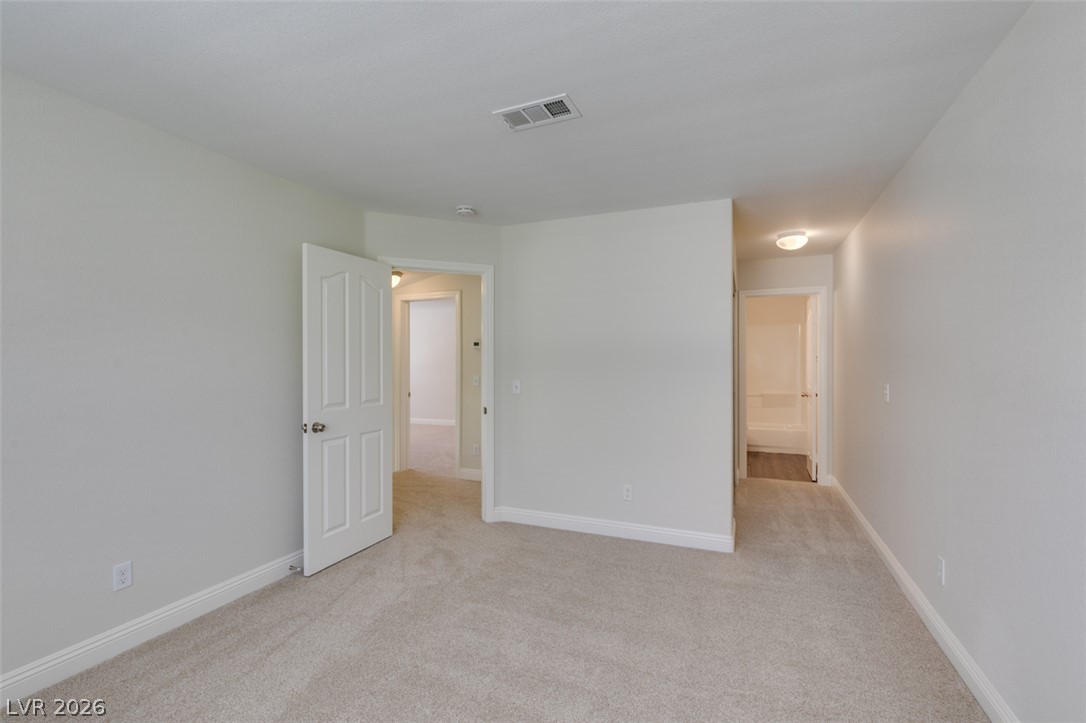 200 Luninborg Street Henderson, NV 89074 - Photo 25 of 40 A well-lit, neutral-toned room features clean carpeting and an inviting open doorway.