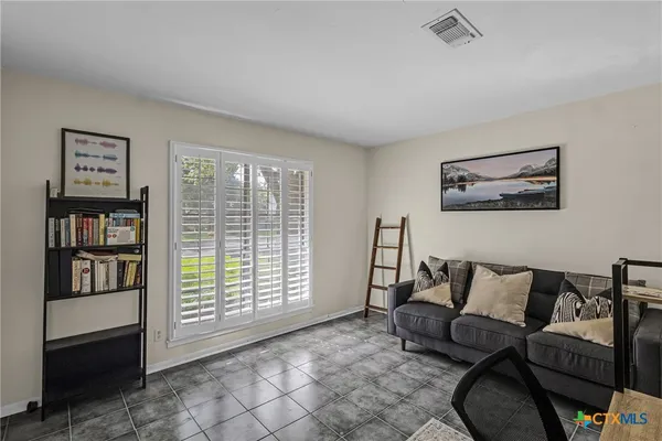 a living room with furniture and a book shelf