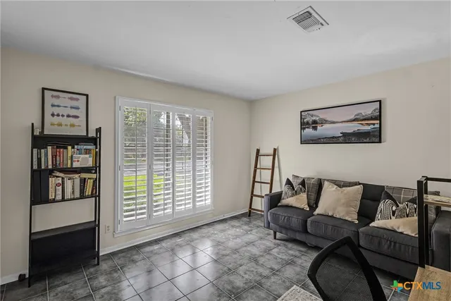 a living room with furniture and a book shelf