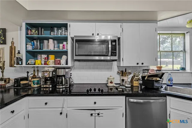 a kitchen with stainless steel appliances a sink a stove and cabinets