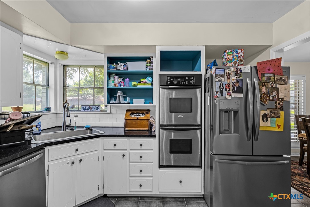 1604 North Cleveland Avenue Cameron, TX 76520 - Photo 21 of 46 a kitchen with stainless steel appliances granite countertop a refrigerator sink and cabinets