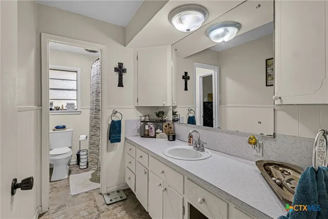 a spacious bathroom with a double vanity sink mirror and toilet